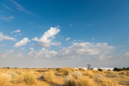 Tent camping site hotel for tourist  in the thar desert under blue sky