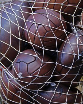 Number of vintage footballs in a white net