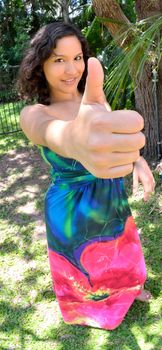 Young lady making a success gesture. Wide angle lens exaggerating the size of the thumb.