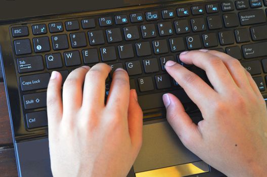 Busy hands working on a notebook keyboard