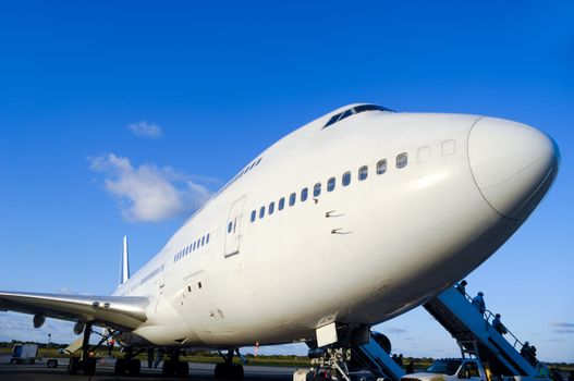 Air travel - A parked plane is loading off Passengers in an airport