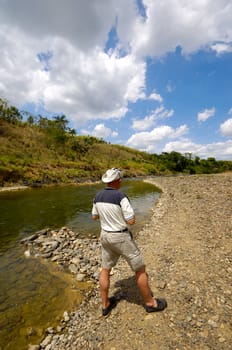A turist is standing near river in green nature. Dominican Republic.