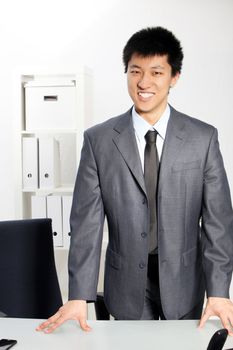 Asian business man standing at his desk