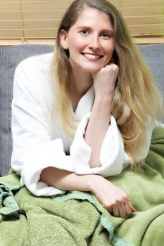 Close up portrait of smiling mid aged female in white bathrobe