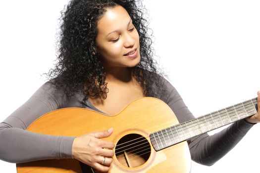 Curly hair woman playing guitar in a close up portrait