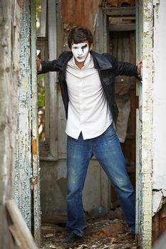 Guy mime against the old wooden door. Mime with a force of an old door opens