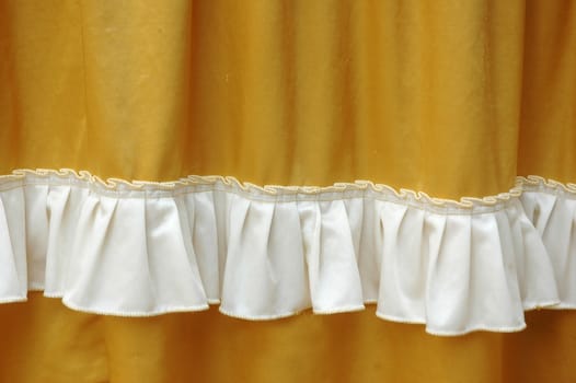 golden fabric decoration with white fringe