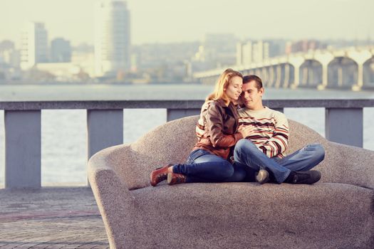 couple embracing, sitting on a background of the city