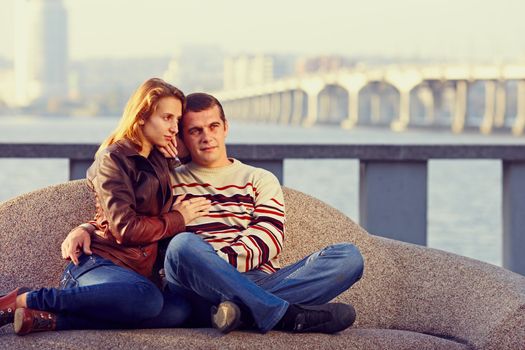 couple embracing, sitting on a background of the city