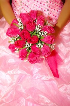 a red bridal bouquet in  the hands of the bride dresses pink