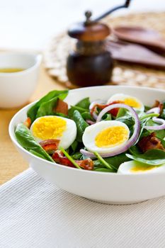 Bacon with boiled egg and spinach salad by salad dressing