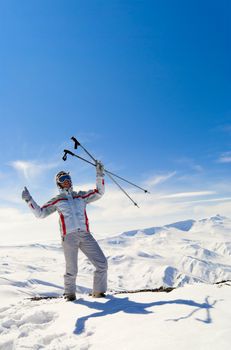 Happy beautiful skier posing on the top of mountain