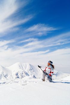 Beautiful skier on the top of mountain looking at the sky