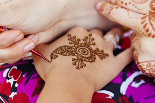 The Indian pattern is drawn a girl. Mehandi