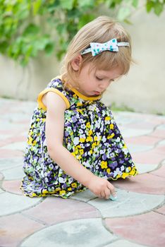 Little girl drawing images by chalk