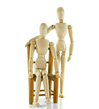 one wooden puppet giving care to other sitting model