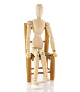 wooden puppet sitting on chair isolated on white background