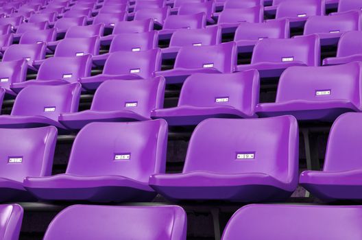 Purple Empty plastic seats at stadium open door sports arena