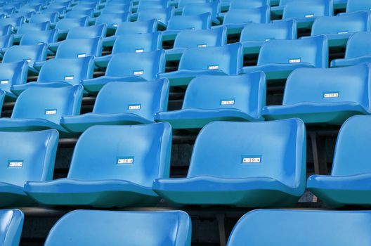 Blue Empty plastic seats at stadium open door sports arena