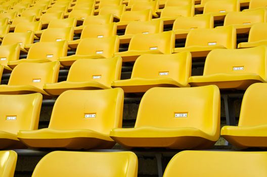 Yellow Empty plastic seats at stadium open door sports arena