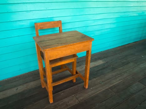 Old wood desk and chair on wood floor and light green wall