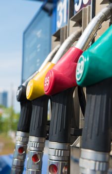 Four gas pump nozzles by closeup .