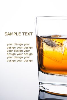 glass of whiskey with ice cubes on white background