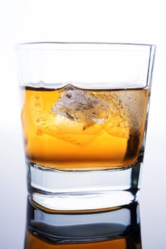 glass of whiskey with ice cubes on white background