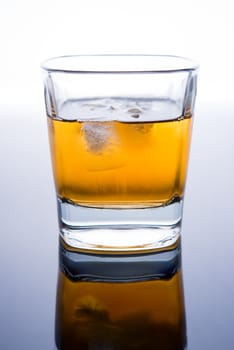 glass of whiskey with ice cubes on white background