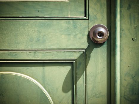 Old iron doorknob on Green wood door