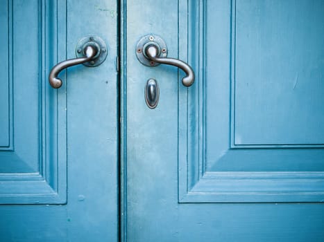 Old Door handles with an old double door painted with blue