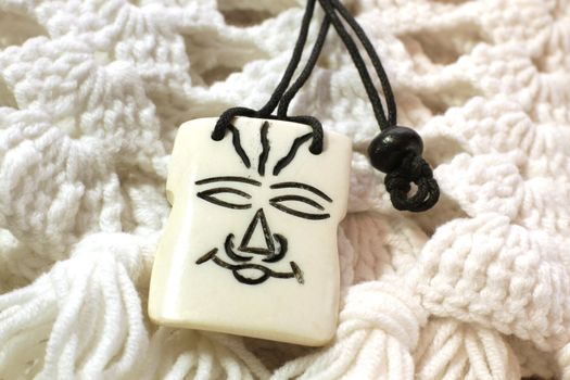 ivory african amulet on knitted white scarf