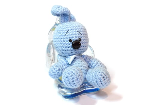 blue knitted hare sitting in the support for mobile telephone