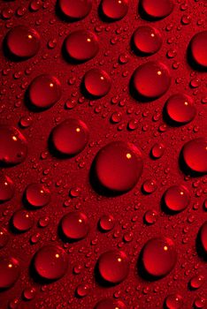 Crystal clear water drops over red background