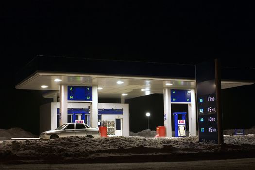 Kind on a gasoline station in the winter at night