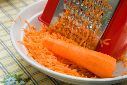 Crude grated carrots in a white cup
