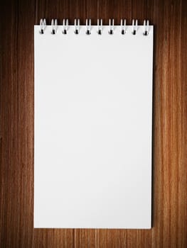 Long blank white note book vertical on wood table background