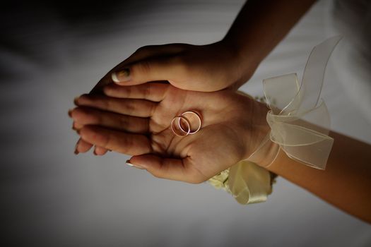 Wedding rings. Young bride on background of wedding dress in the outstretched hands holding two wedding rings