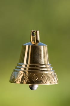 Four brass handbell on a green background