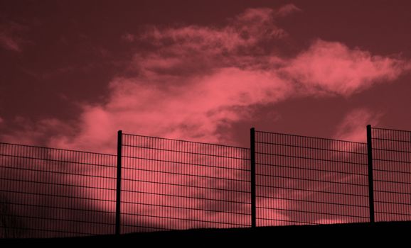 Black Fence against threadening red sky