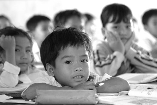 Young schoolkids in a small fishing village in Vietnam looking curiously at the tourists. By exception we were allowed into the school but the kids had to remain seated and continue with the lessons which was a real challenge for them!