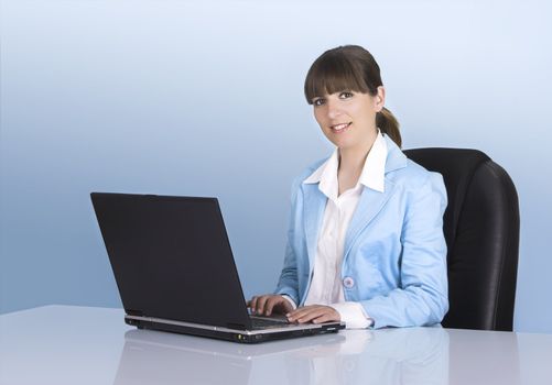Satisfied businesswoman working with a laptop on a blue background