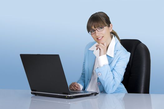 Satisfied businesswoman working with a laptop on a blue background