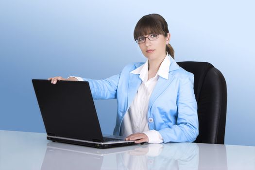 Satisfied businesswoman working with a laptop on a blue background