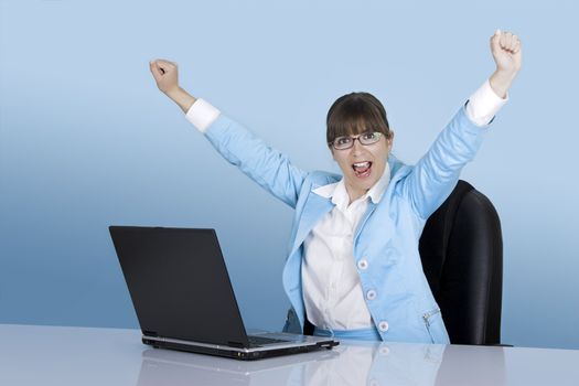 Happy businesswoman working with a laptop on a blue background