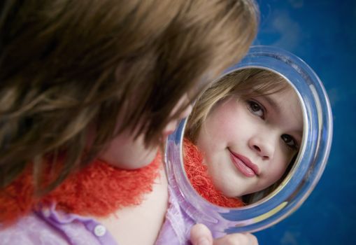 Little Girl Playing Dress-Up Looking in a Handheld Mirror