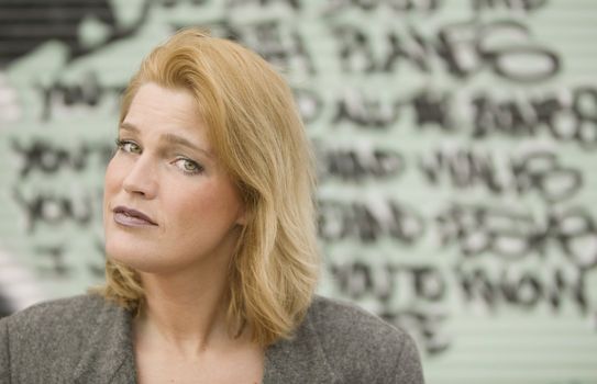 Portrait of a blonde woman in front of graffiti