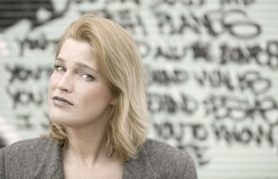 Portrait of a blonde woman in front of graffiti