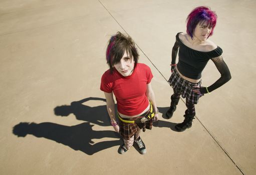 Two Punk Girls Standing on a Concrete Slab