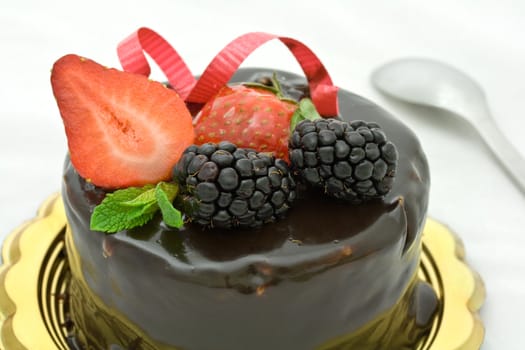 Strawberry and chocolate cake decorated with fruits and mint leaves